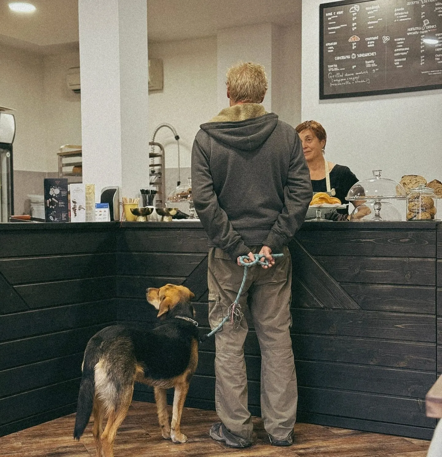 A customer and their dog waiting at the Lembas counter, being served under the chalkboard menu